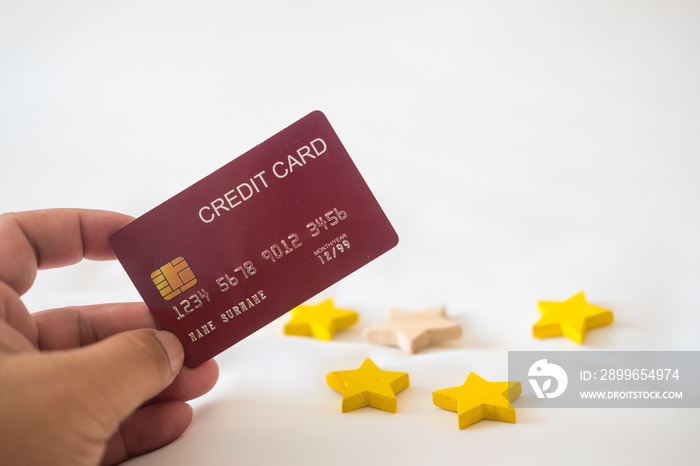 Holding a red credit card and four star shape. The concept of pay by credit card.