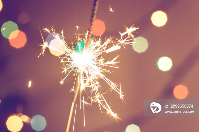 Bengal fire sparkler and colorful bokeh christmas new year background