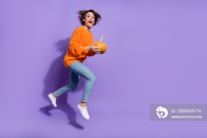 Full length body size view of nice cheery crazy girl jumping holding pumpkin running isolated on bri