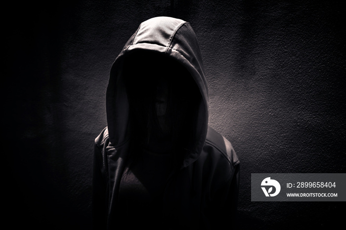 Woman wearing hoodie hiding in the dark,Scary background for book cover