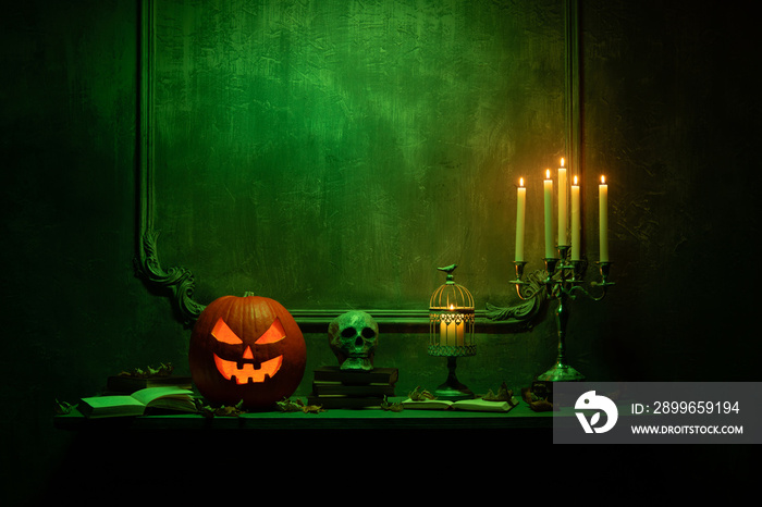 Scary laughing pumpkin and old skull on ancient gothic fireplace. Halloween, witchcraft and magic.