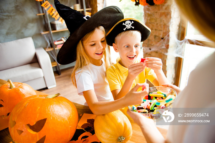 Wow! Sweets for us! Very cheerful excited kids in carnival head wear, with treats, rear cropped view