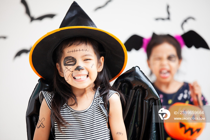 Happy asian little child girl in costumes and makeup having fun on Halloween celebration