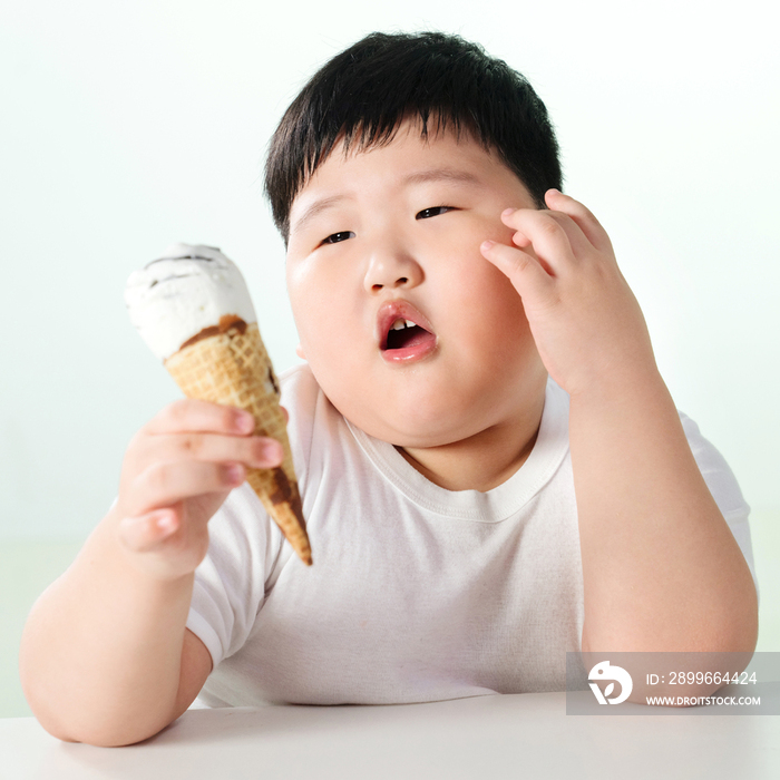 可爱的肥胖小男孩吃冰淇淋
