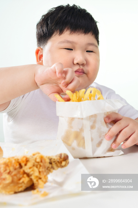 可爱的肥胖小男孩吃炸鸡薯条