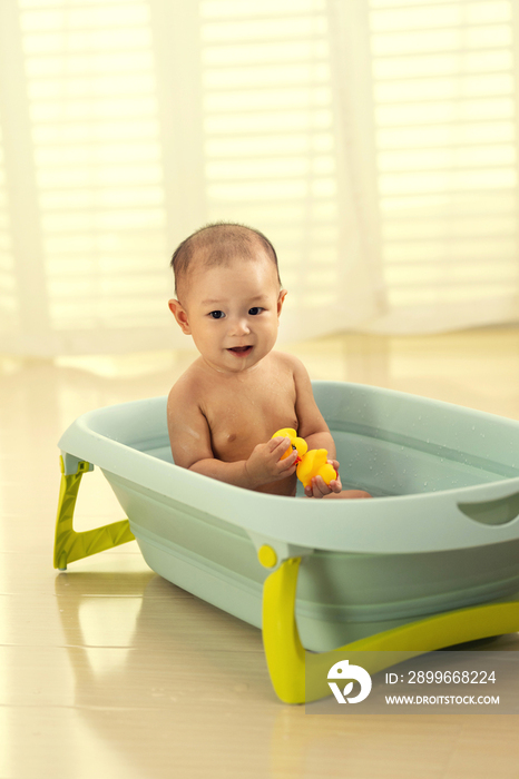 可爱宝宝坐在浴盆里洗澡