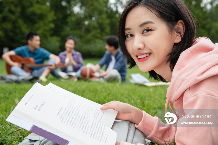 大学生在草地上享受课余时间