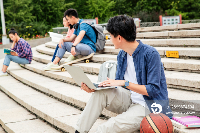 快乐的大学生坐在台阶上学习