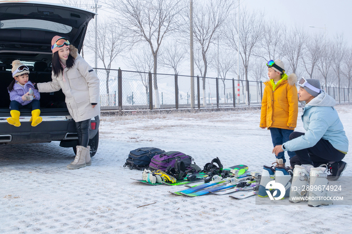 停车场内清点滑雪装备的一家四口