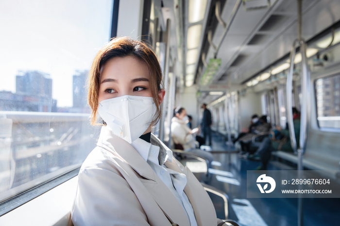 戴口罩的年轻女人乘坐地铁