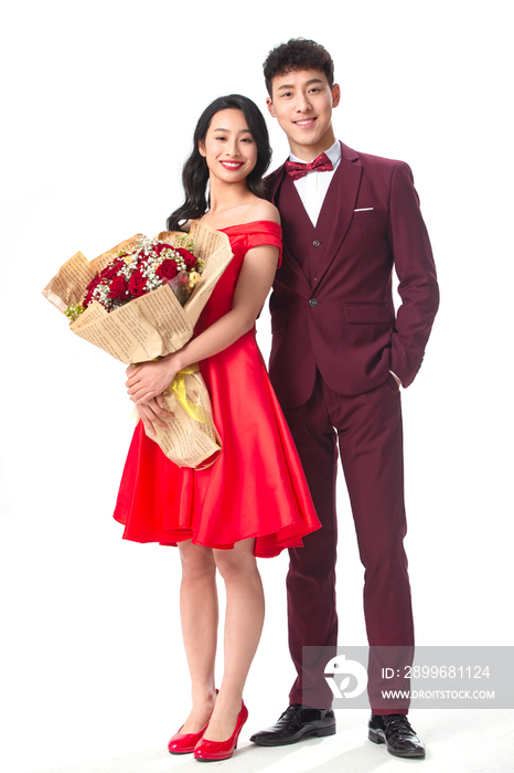 身穿红色礼服的情侣拿着玫瑰花