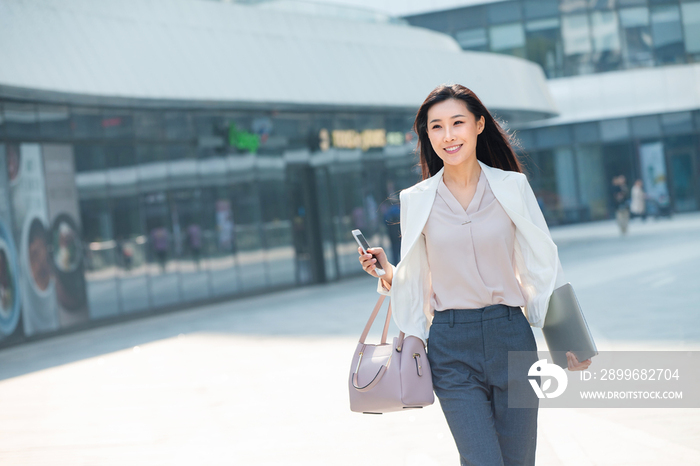 在外面步行的青年商务女人