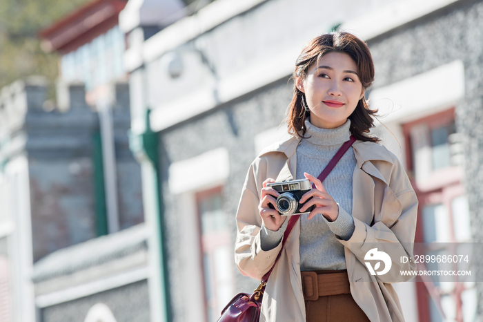 旅行的青年女人拿着照相机