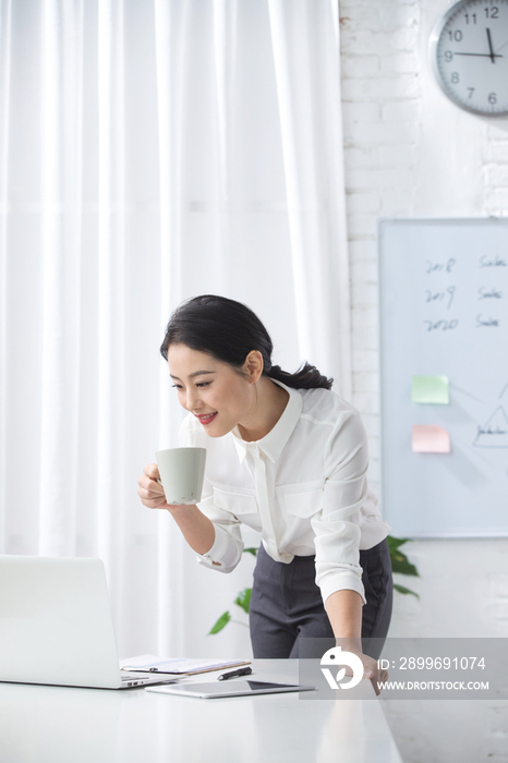 青年商务女人使用笔记本电脑办公