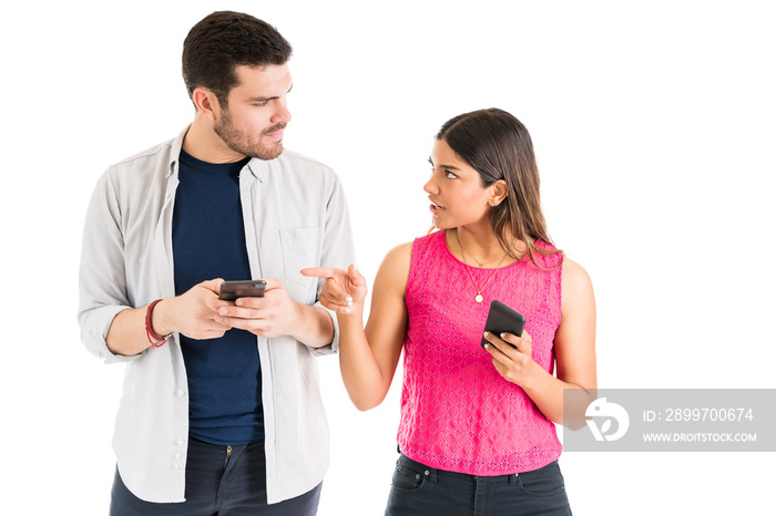 Woman Confronting Boyfriend With Smartphone In Studio