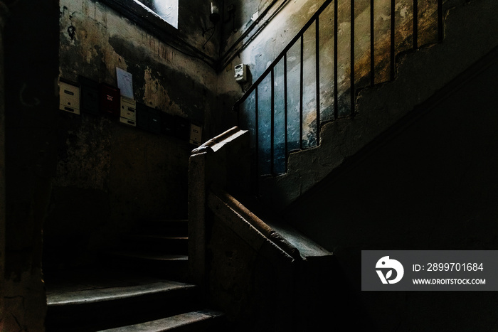 意大利巴里旧城区一栋废弃建筑黑暗中庭的旧石楼梯。