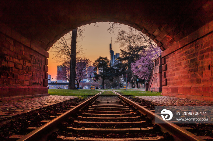 Evening mood in Frankfurt with the skyline of the financial district. Old train track with historica