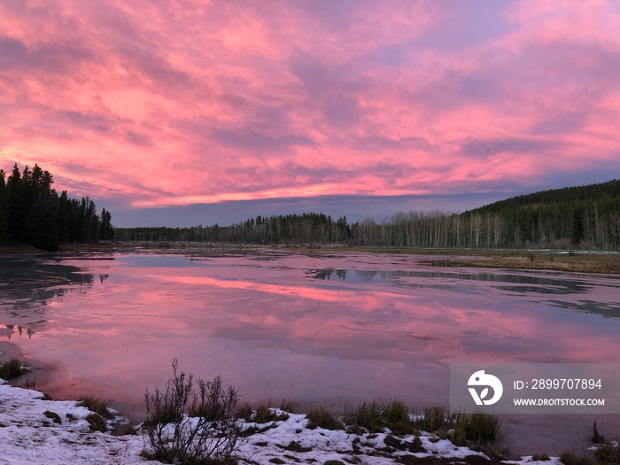 Red skies during sunset over Mclean Pond near Bragg Creek, Calgary, Alberta. Popular fishing pond in