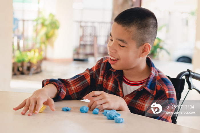 Asian disabled child on wheelchair molding clay, Fun and entertaining activity for training small an