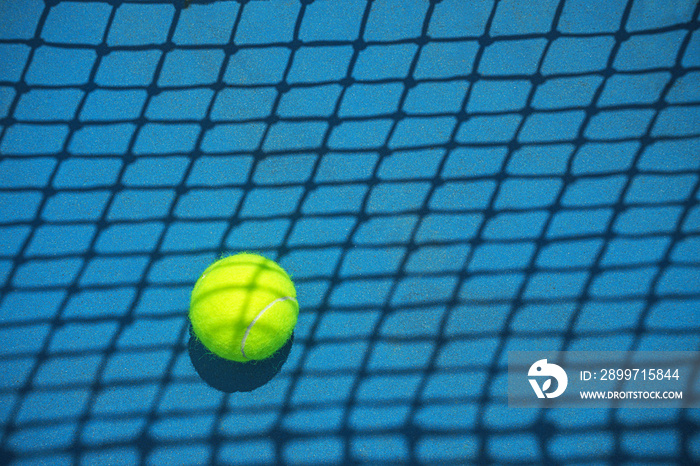 Summer sport concept with tennis ball and net on hard tennis court. Flat lay, top view, copy space.