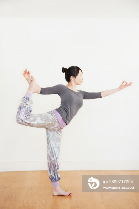 Woman standing on one leg, side view