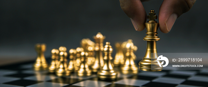 Close up hand choose king chess from the golden team on chess board concepts of leadership and busin