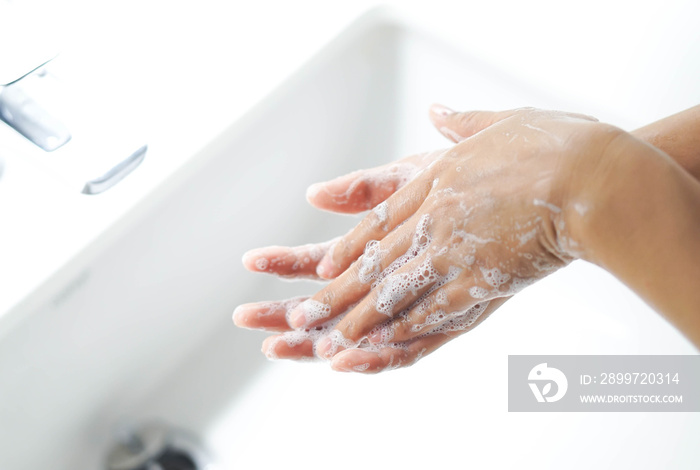 Closeup womans hand washing with soap in bathroom, selective focus