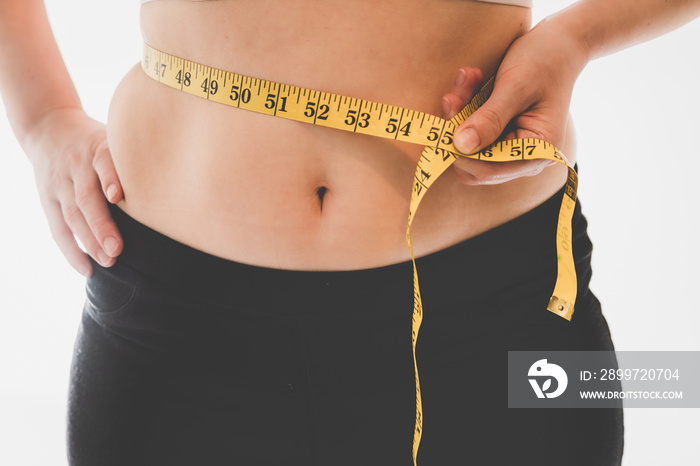 young woman measuring her waist