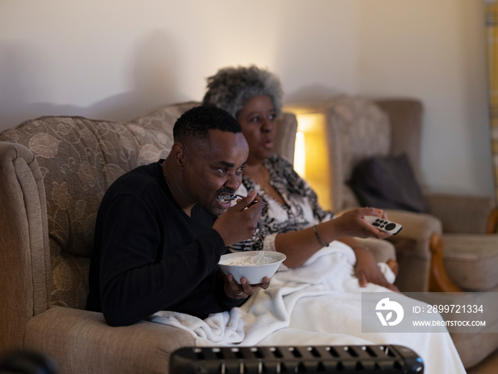 Couple sitting on sofa and watching TV