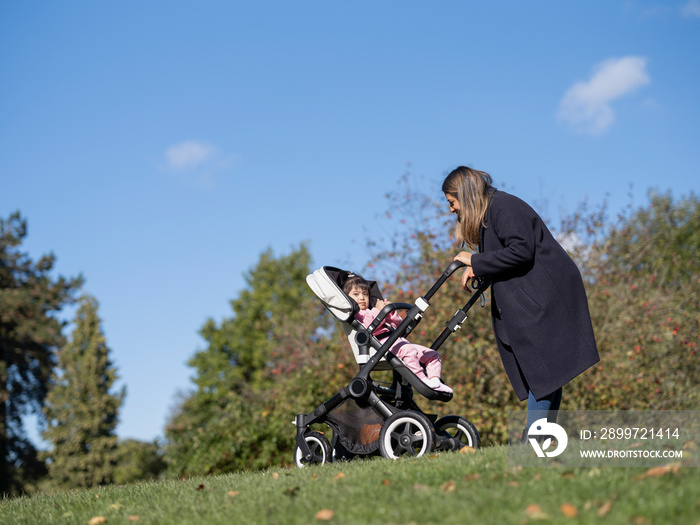 Mother walking with daughter with Down syndrome in stroller