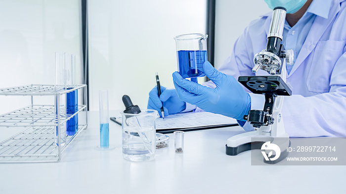 医学或科学研究人员或男医生在实验室里看着透明溶液的试管