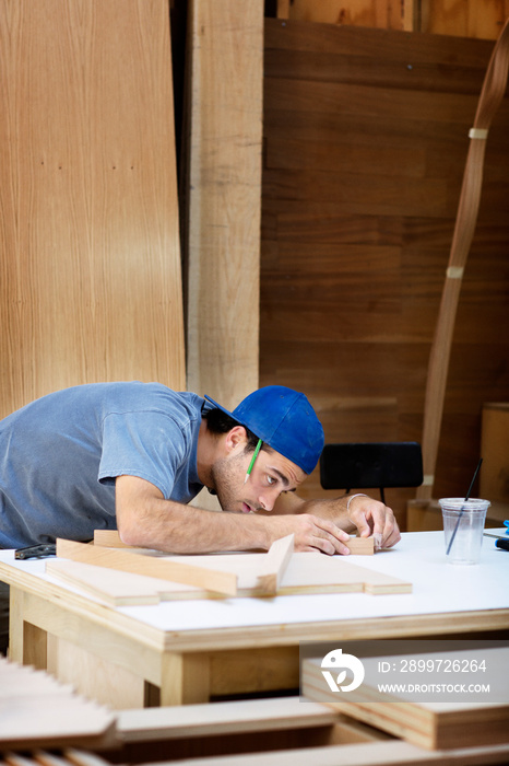 Side-view of young carpenter working