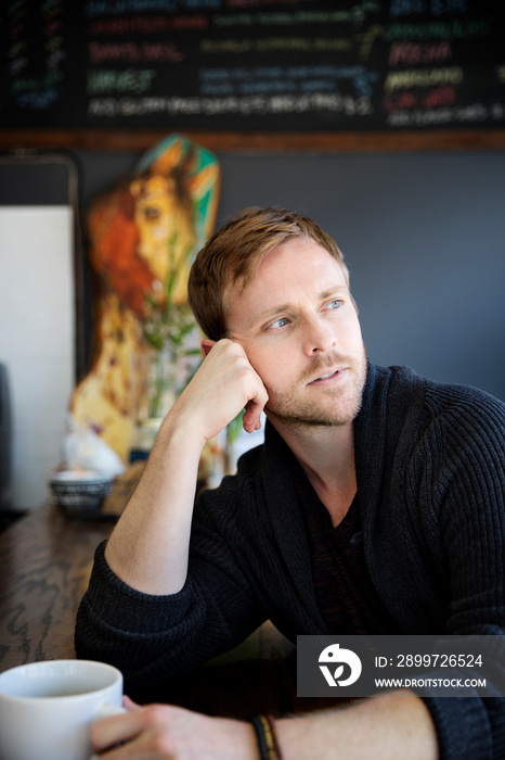 Portrait of man daydreaming in cafe