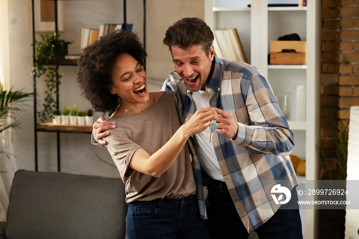 Smiling couple is taking keys from their new apartment. Husband and wife are moving into the apartme