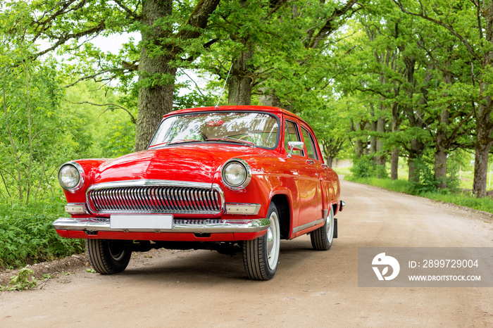 Red vintage car on gravel road