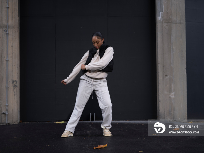 Teenage girl in sports clothing dancing in city