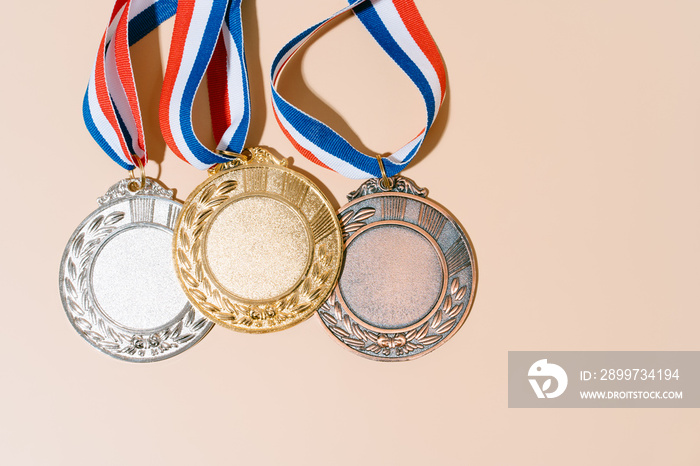 粉彩背景上的三枚奖牌（金、银、铜）。接受奖项和胜利者。复制空间