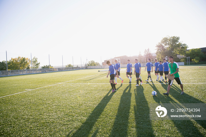 Soccer team walking on field with coach.