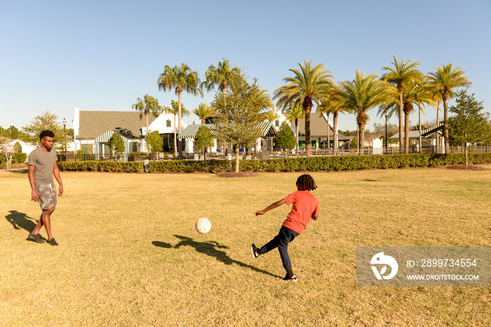 Father and son playing soccer