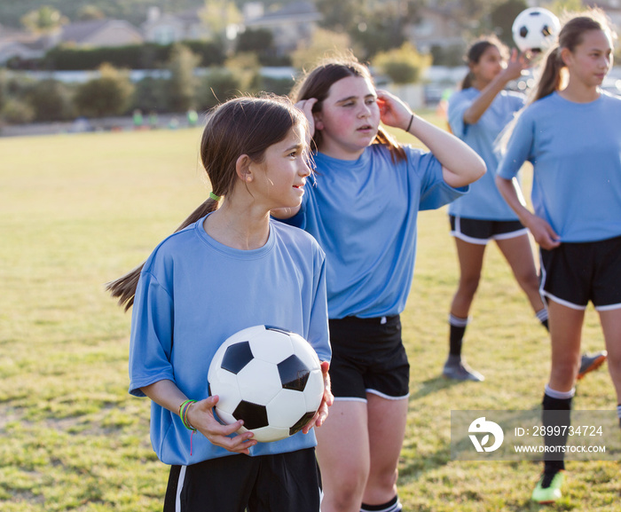 Girls practicing soccer on field