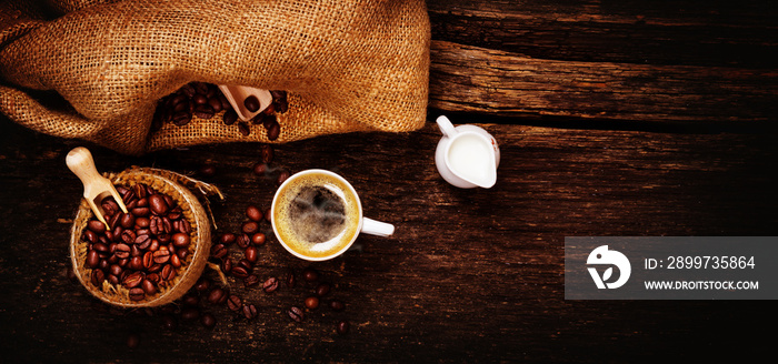 Espresso, Milchkännchen und frisch geröstete Kaffeebohnen auf Holztisch