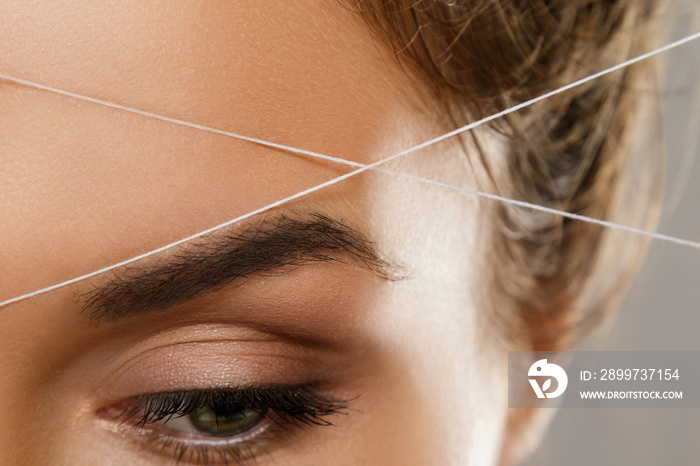 Eyebrow threading - epilation procedure for brow shape correction