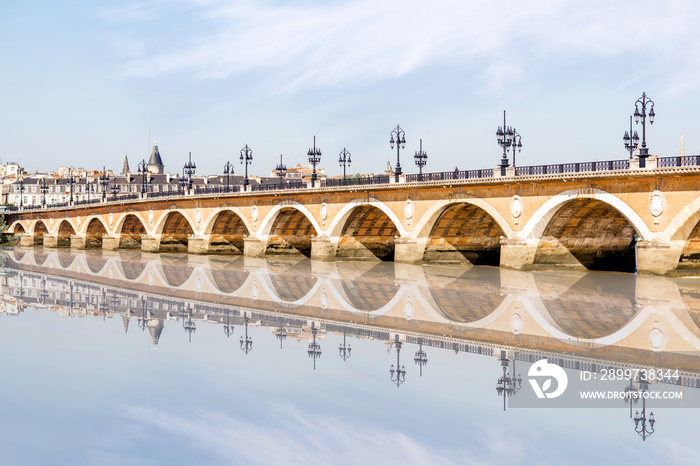 View on the famous saint Pierre bridge with reflection on the water in Bordeaux city, France