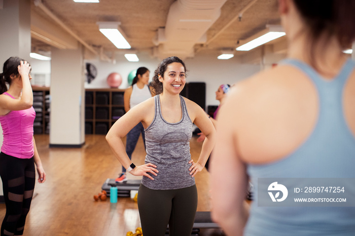 Female athletes talking while standing in gym