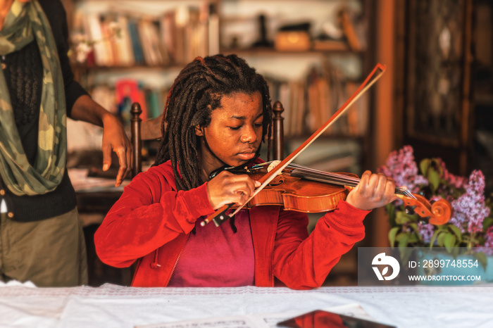 girl practicing and learning violin play at home