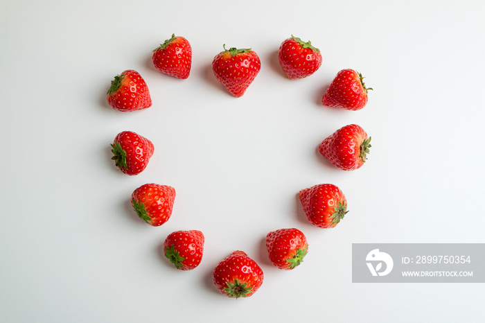 白色背景的草莓，俯视图。浆果图案。w形新鲜草莓制成的心形框架