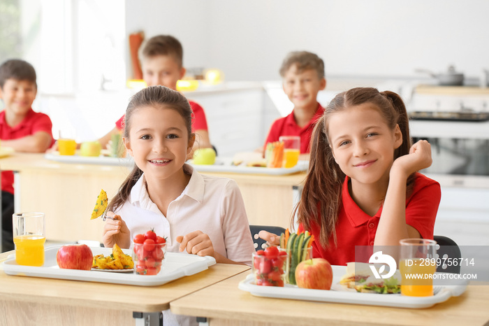 Pupils having healthy lunch in classroom