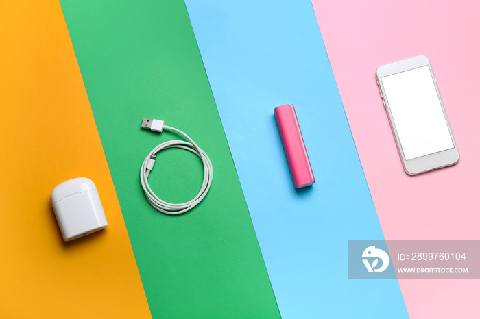 带手机、USB线和彩色背景耳机的充电宝