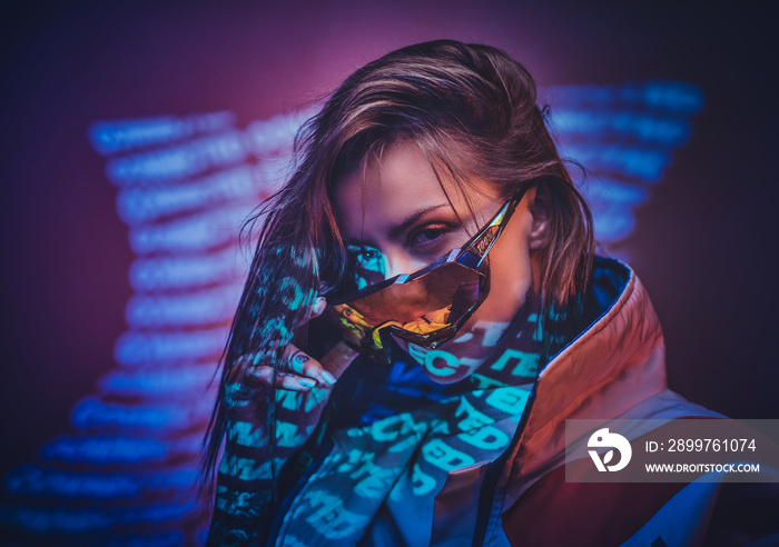 Futuristic young woman making an eye contact in neon studio lights of text projection, wearing racin