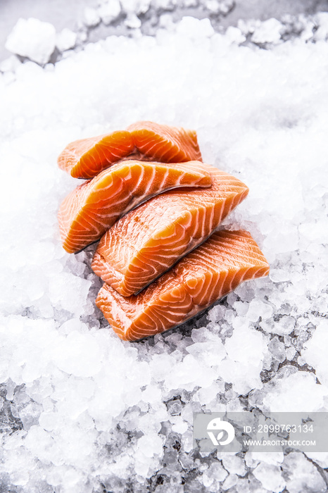 Salmon fillets portioned on ice and empty kitchen board